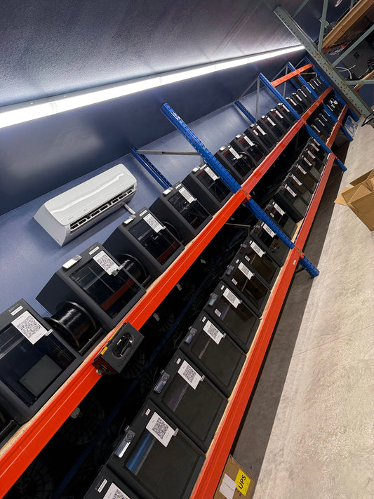 A row of Bambu Lab printers on the Farm Sip Supreme print farm in Lismore, Minnesota